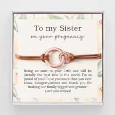 a card that says to my sister on your pregnancy with two interlocked bracelets