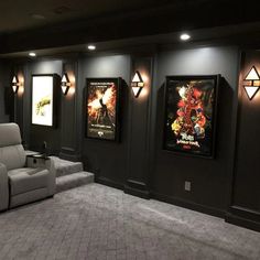 a home theater with two recliners and three movie posters on the wall