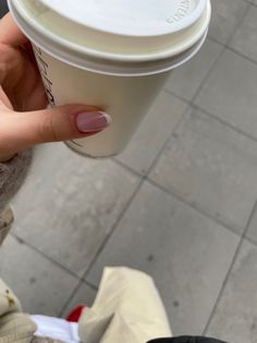 a woman holding a cup of coffee in her hand