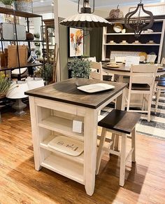 a kitchen island in the middle of a room with chairs around it and shelves on either side