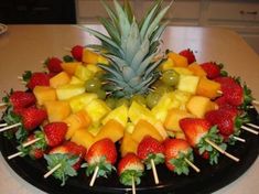 a fruit platter with strawberries, pineapples and grapes