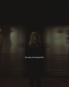 a woman standing in front of a train at night with the words not angry, just disappointed