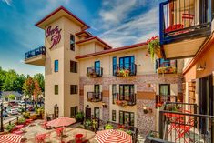 an apartment building with patio furniture and umbrellas