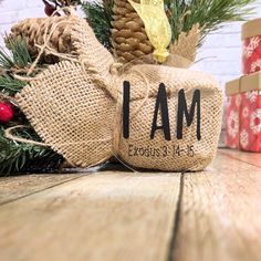 a burlap sack with the word i am on it sitting next to christmas presents