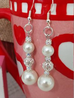 These beautiful glass pearl earrings feature a silver filigree bead and small AB faceted spacer beads that sparkle in the light.  The ear wires are sterling silver and are the perfect compliment for your special occasion or with your favorite jeans. Elegant Silver Beaded Earrings For Gift, Elegant White Earrings With Silver Beads, Elegant Silver Beaded Earrings As A Gift, Elegant Silver Beaded Pearl Earrings, Elegant Silver Beaded Round Earrings, Elegant Sterling Silver Beaded Earrings, Silver Beaded Earrings With Pearl Drop, Silver Beaded Earrings For Wedding, Elegant Silver Beaded Hypoallergenic Earrings