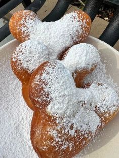 powdered sugar covered donuts in a white bowl