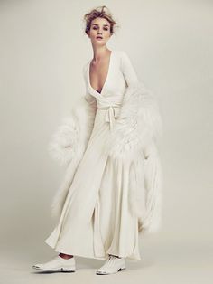 a woman in a white dress and fur coat