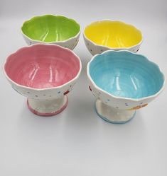 four different colored bowls sitting next to each other