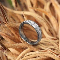 a wedding ring sitting on top of dry grass