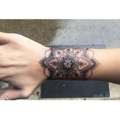 a person's arm with a tattoo on it, and the wrist is covered in black ink