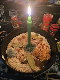 a birthday cake with a lit candle in it and some spices on the table next to it