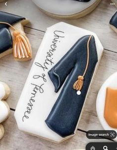 a decorated cookie with an image of a graduation cap and gown on it's side