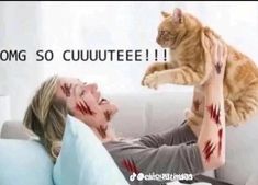 a woman laying on top of a couch next to a cat with blood all over her face