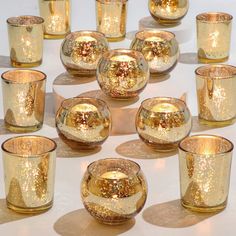 many gold colored glass cups and glasses on a table