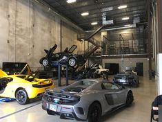 several cars are parked in a large garage