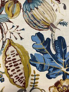 a blue and yellow floral fabric with leaves, flowers, and acorns on it