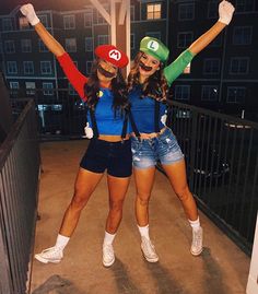 two women dressed up in mario and luigi bros costumes posing for the camera at night