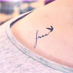 a small tattoo on the back of a woman's shoulder that reads, free