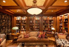 a living room filled with lots of furniture and bookshelves covered in wooden shelves