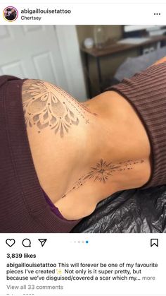 the back of a woman's neck with an intricate tattoo on her left side