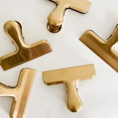 four different types of handles on a white surface, one gold and the other black