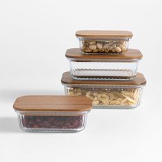 three glass containers filled with nuts and other food