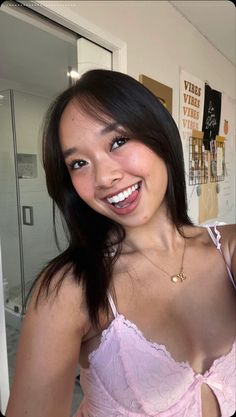 a woman in a pink bra smiling at the camera