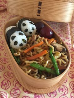 a bowl filled with noodles, vegetables and panda bears