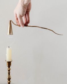 a person is holding a stick over a candle