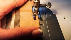 someone is using a sewing machine to sew something on the side of a piece of fabric