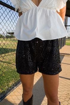 DESCRIPTION: Dazzle in our Blitz Sequin Shorts – a perfect balance of glamour and comfort. Whether you're stepping out for a night on the town or a special event, these shorts is designed to turn heads and make a statement. Pair with our matching shirt or the top of your choosing! DETAILS: Elastic waistband Satin lining Lined shorts True to size Shane is 5'10" with a 27" waist + 32B bust and is wearing a small. Carleigh is 5'2" with a 28" waist + 34B bust and is wearing a small. FABRIC: 100% Pol Glamorous Bottoms With Built-in Shorts, Party Pants With Built-in Shorts, Black Stretch Glamorous Bottoms, Glamorous Stretch Black Bottoms, Glamorous Black Stretch Bottoms, Spring Bottoms With Built-in Shorts For Going Out, Summer Party Pants With Built-in Shorts, Black Bottoms For Night Out With Short Legs, Black Shorts With Built-in Shorts For Night Out