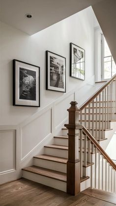 a staircase with pictures on the wall and wooden steps leading up to an upper floor