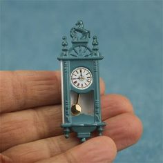 there is a miniature clock in the palm of someone's hand