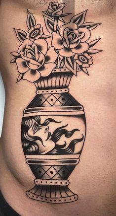 a woman's stomach with flowers in a vase tattoo on the side of her belly