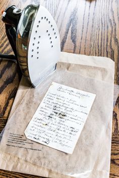 an iron on top of a piece of brown paper next to a bag with writing