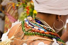 the back of a woman's body covered in lots of bracelets and beads