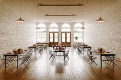 an empty room with tables and chairs set up for a formal function in the center