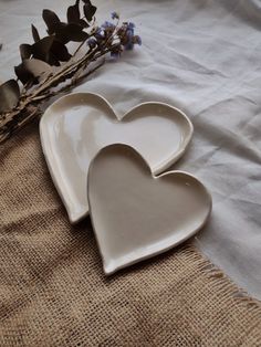 two heart shaped dishes sitting on top of a table