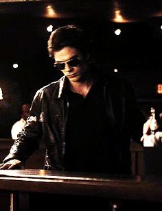 a man standing at a bar in the dark