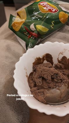 a bowl filled with ice cream next to a bag of chips