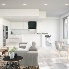 a living room filled with furniture next to a kitchen