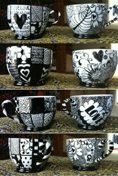 four different cups with hearts and flowers painted on them, all in black and white