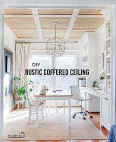 a white desk sitting under a window in a living room next to a wooden ceiling