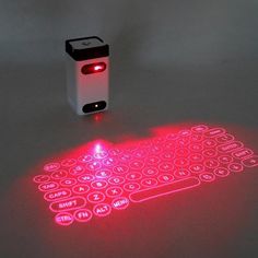 a lit up keyboard sitting on top of a table next to a small light bulb