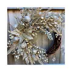 a wreath with silver and gold decorations hanging on a wooden wall