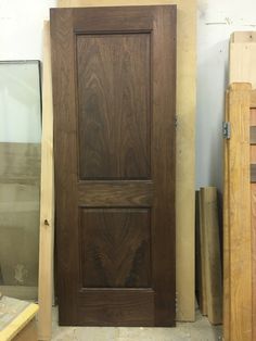 a wooden door sitting in the middle of a room next to other woodworking supplies