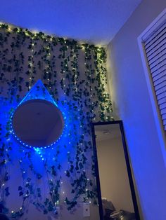 there is a blue light in the mirror and some plants on the wall behind it