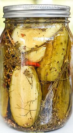 a jar filled with pickles sitting on top of a table