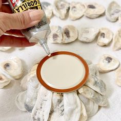 a person is dipping something into a sauce in front of oysters on the table