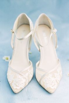 a pair of white shoes sitting on top of a blue surface